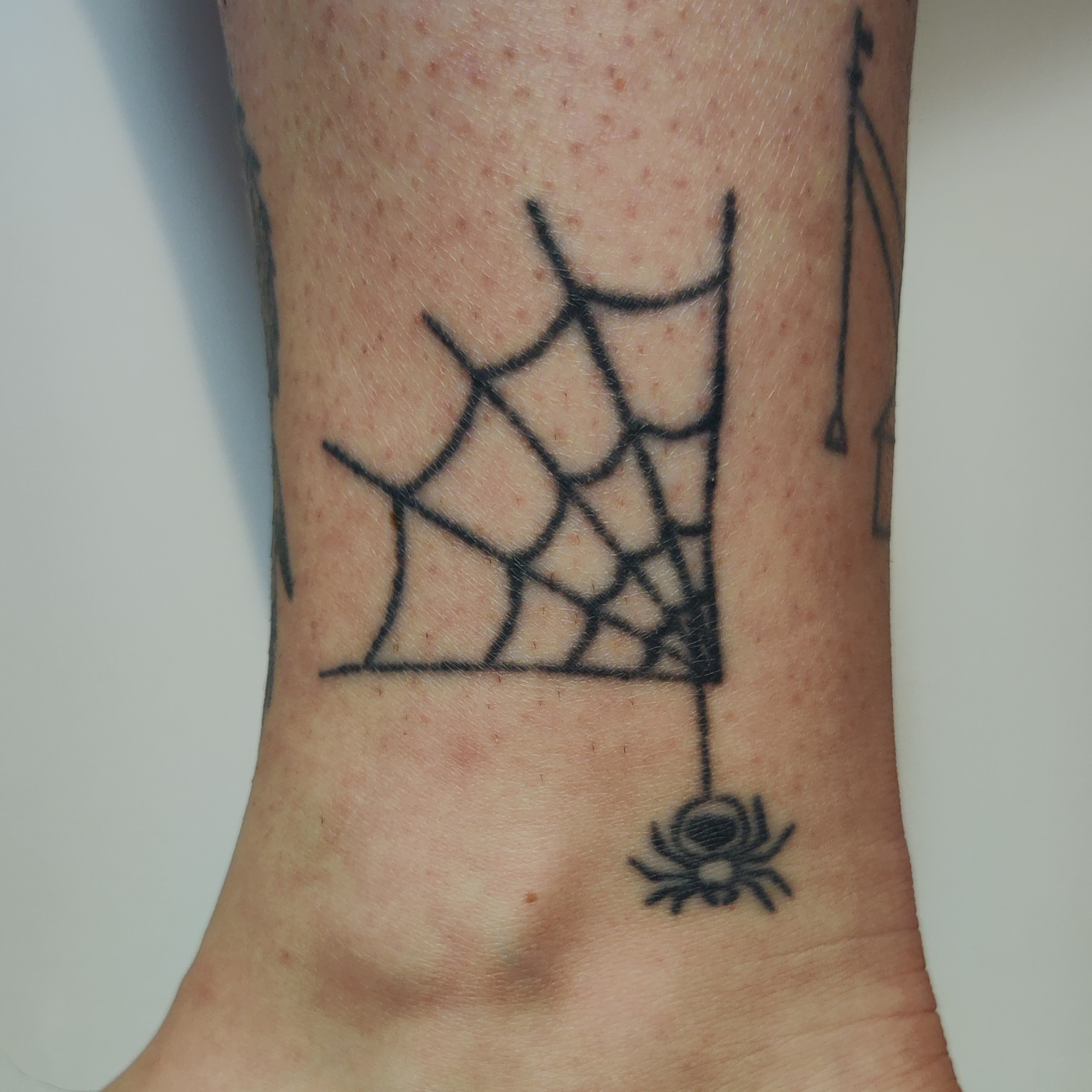 Spinnenwebe Handpoke Tattoo